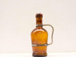 Vintage amber glass bottle with a metallic handle, perfect for decor or drink storage.