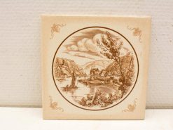 Charming vintage ceramic tile featuring a serene river landscape with sailboats and quaint homes.