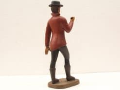 Vintage figurine of a stylish man in a red shirt and hat, exuding charm.