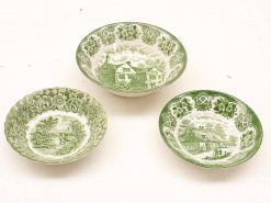 Vintage green transferware bowls featuring intricate scenic and floral motifs, perfect for decor or collection.