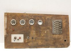 Vintage wooden control panel with gauges and switches, showcasing industrial history and craftsmanship.