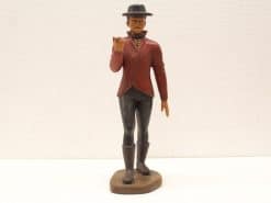 Vintage figurine of a man in a red jacket with a white collar and black pants.