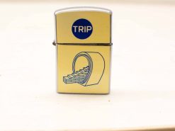 Vintage silver lighter with TRIP logo and unique travel-themed wheel illustration.