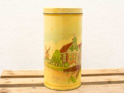 Vintage yellow tin canister featuring a charming Dutch landscape with a windmill and traditional architecture.