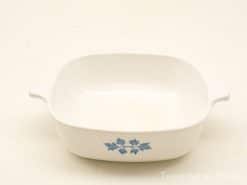 Elegant white ceramic baking dish with blue leaf design and practical handles for easy serving.