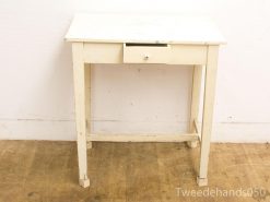 Charming vintage white table with rustic details, perfect for versatile home decor.