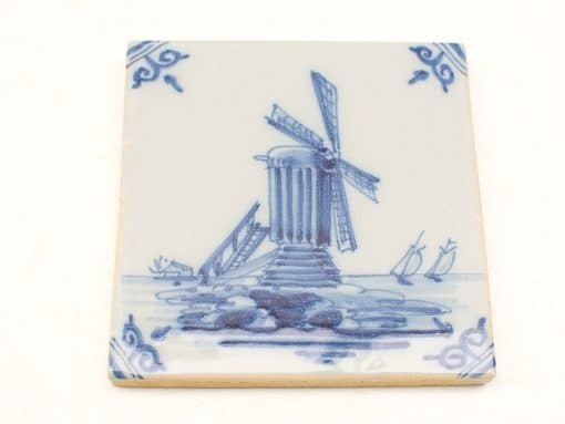 Vintage blue windmill tile featuring serene nature and sailing boats in a picturesque landscape.