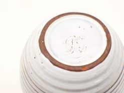 Vintage ceramic bowl with glossy white glaze and distinct brown rim, featuring JF embossed mark.