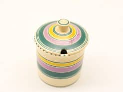 Colorful ceramic storage container with lid, ideal for organizing small items in style.