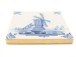 Vintage ceramic tile featuring a Dutch windmill and serene water landscape in blue and white.