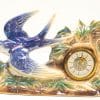 Whimsical vintage clock featuring a flying swallow and elegant nature-inspired decorations.