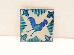 Vibrant rooster tile with folkloric design, showcasing detailed patterns in blue and green hues.