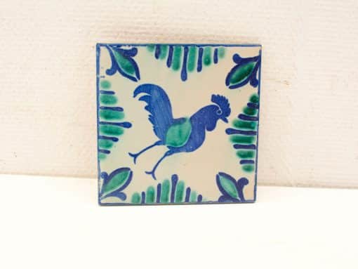 Vibrant rooster tile with folkloric design, showcasing detailed patterns in blue and green hues.