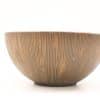 Elegant vintage ceramic bowl with unique vertical texture in warm brown hue. Perfect for decor.