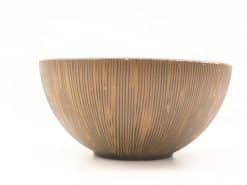 Elegant vintage ceramic bowl with unique vertical texture in warm brown hue. Perfect for decor.