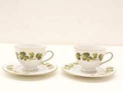 Elegant porcelain teacups with ivy pattern and gold trim, perfect for sophisticated tea gatherings.