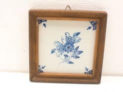 Rustic floral tile in wooden frame, perfect for charming wall decor in any home.