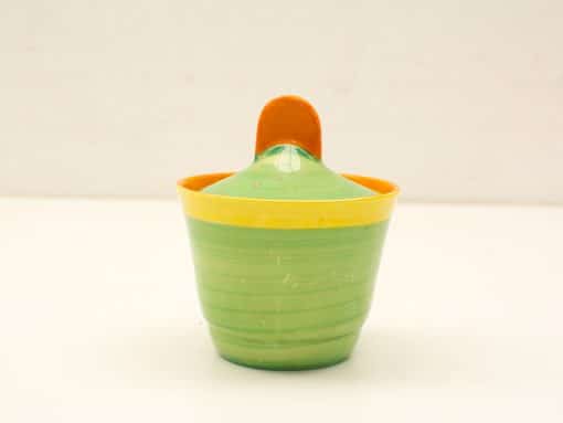 Colorful round container with green body, yellow rim, and orange knob, perfect for storage.