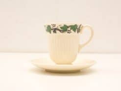 Elegant vintage teacup and saucer with green vine design, perfect for tea parties.