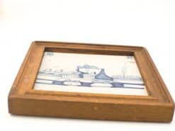 Serene blue and white landscape art in warm wood frame, showcasing quality craftsmanship and elegance.