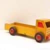 Charming vintage wooden toy truck in bright yellow with red accents for imaginative play.