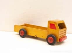 Charming vintage wooden toy truck in bright yellow with red accents for imaginative play.