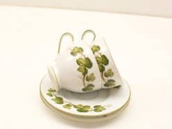 Elegant vintage porcelain tea set with green leaf design and gold trim accents.