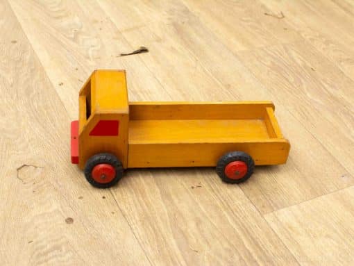 Charming yellow wooden toy truck with red accents, perfect for imaginative play and childhood nostalgia.