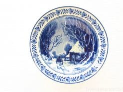 Elegant blue-and-white ceramic plate depicting a serene winter landscape and floral border design.