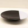 Elegant black and white plate, perfect for stylish decor and versatile serving options.