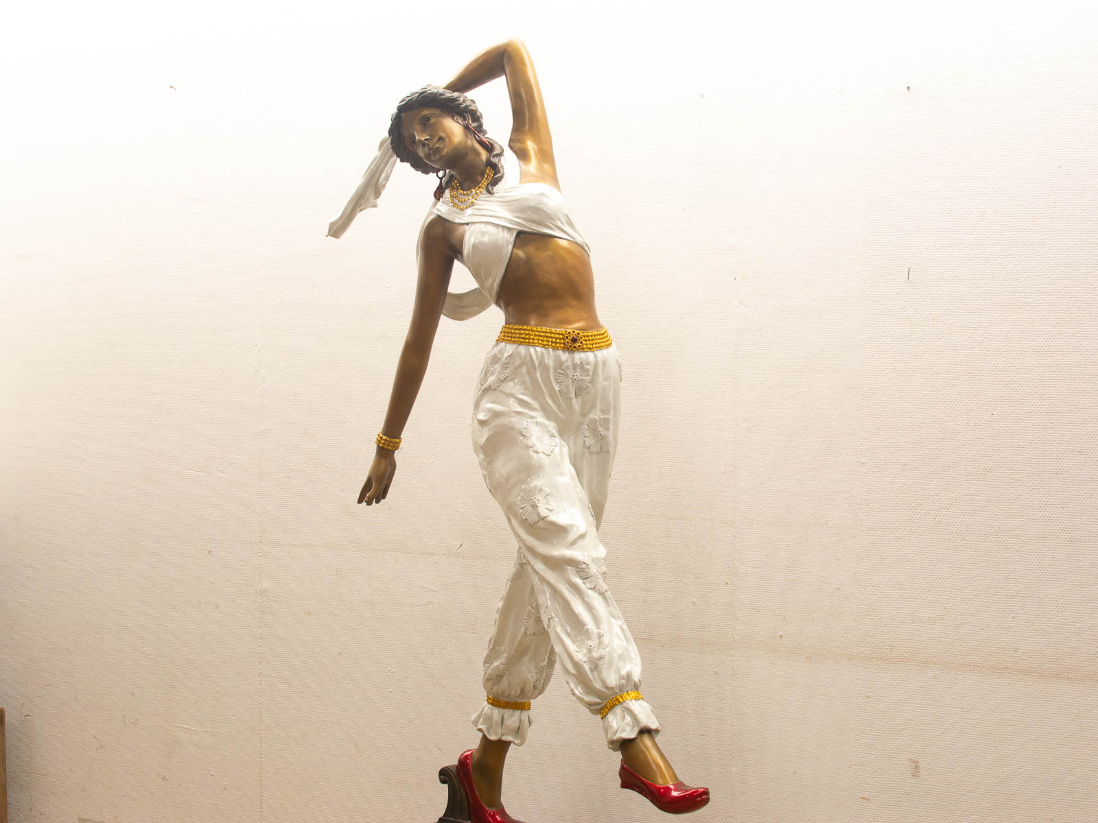 Elegant female dancer sculpture in white with gold accents, capturing grace and modernity.