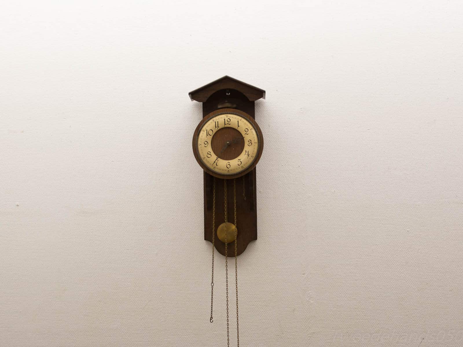 Antique wooden pendulum clock with vintage charm and elegant craftsmanship, perfect for timeless decor.