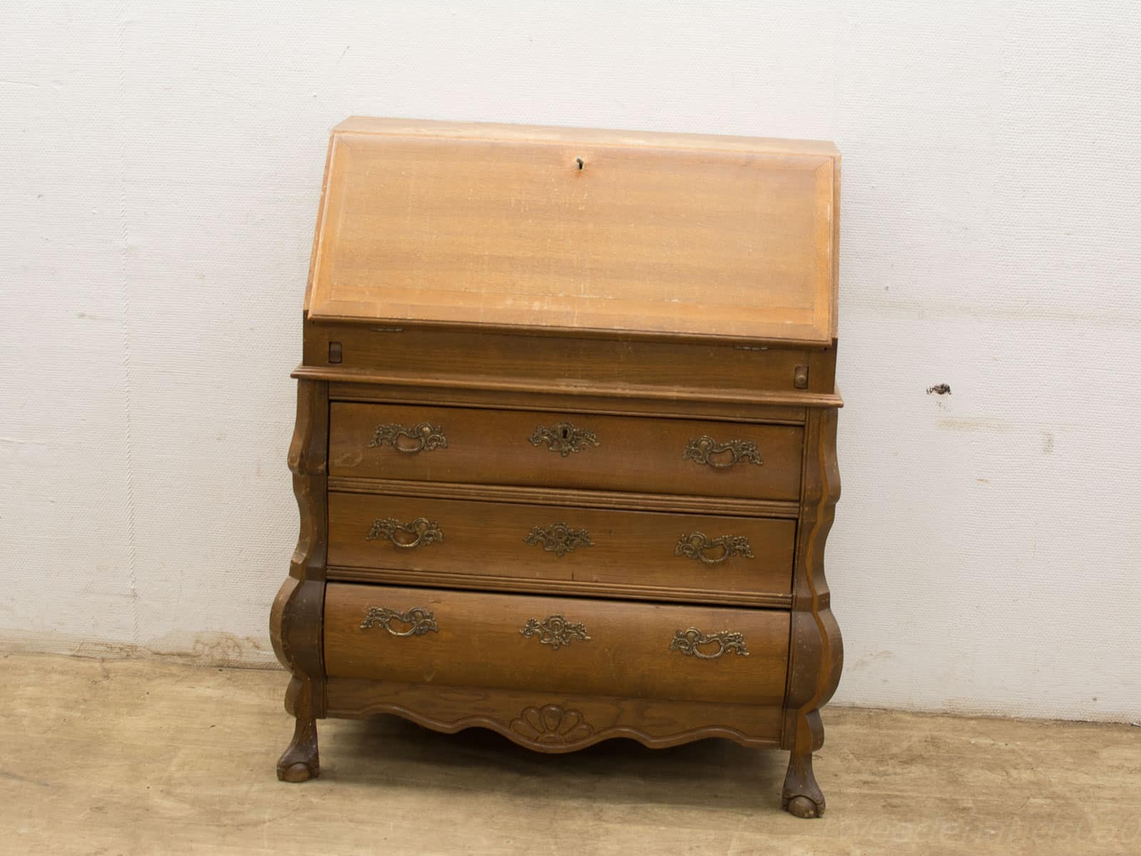 Charming vintage writing desk with ornate handles, slanted top, and warm wood tones.