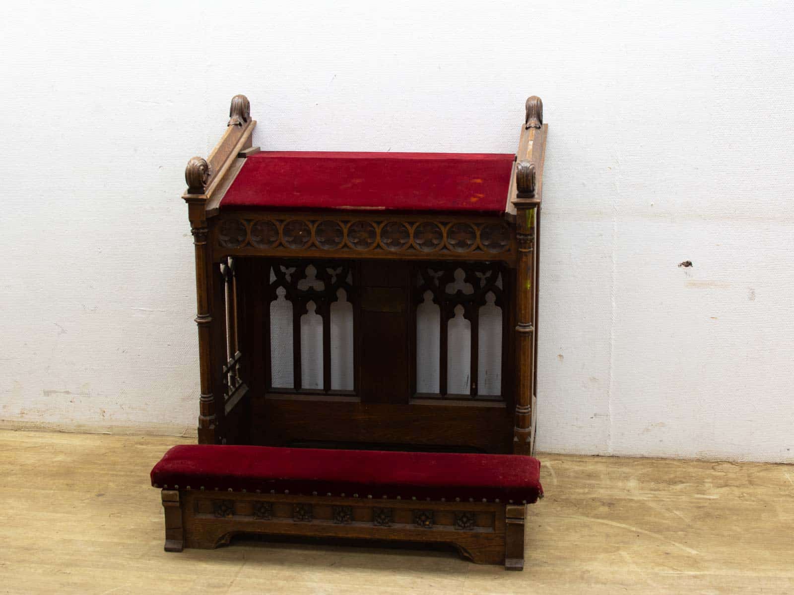 Antique Gothic chair with red velvet upholstery, showcasing intricate wooden details and elegant design.