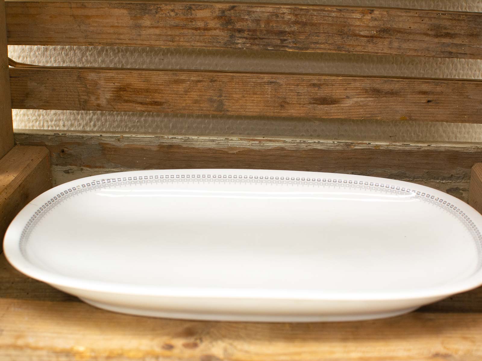 Elegant white oval platter on rustic wooden background, perfect for any dining occasion.