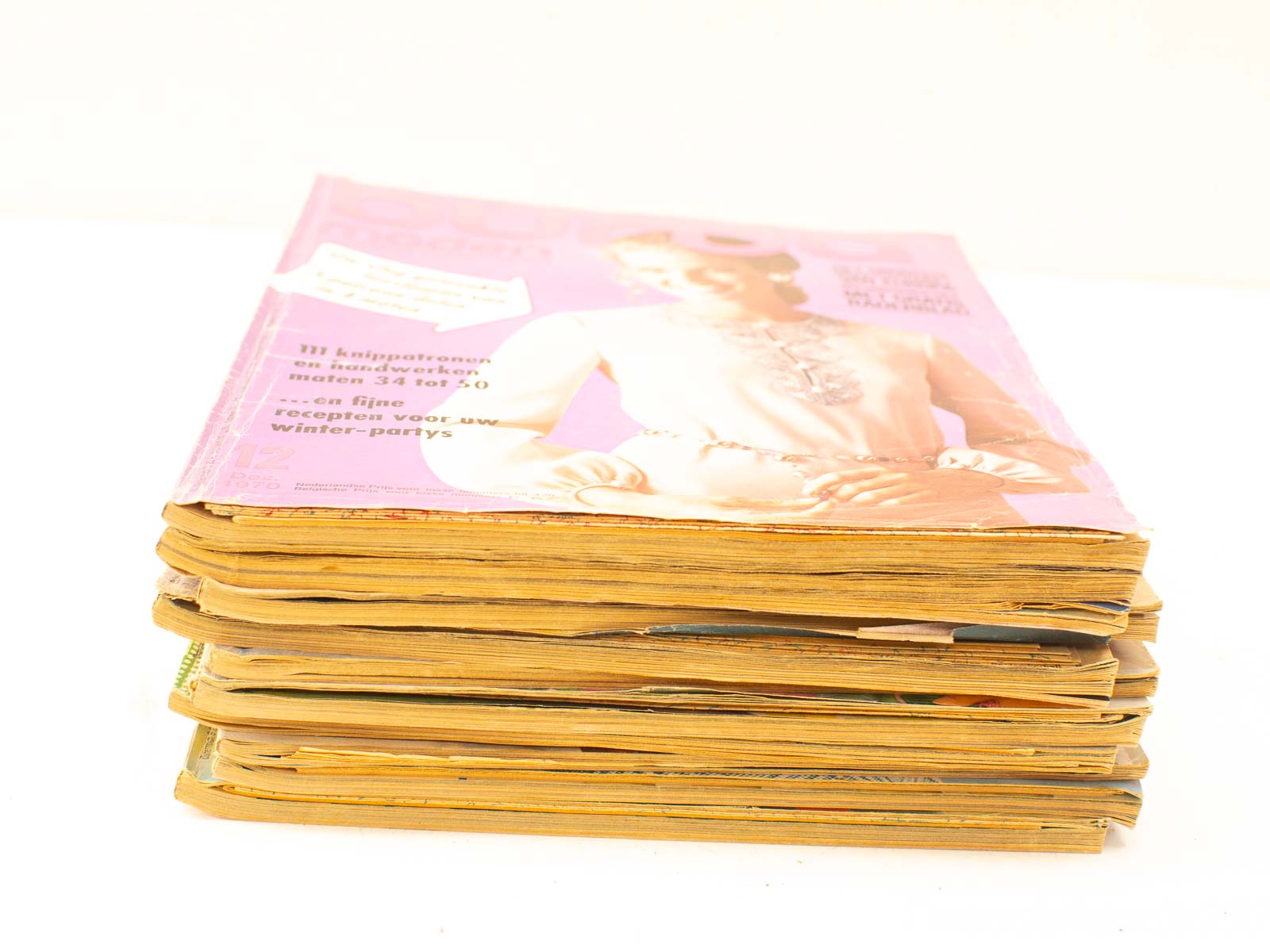 Charming vintage fashion magazines with pink covers, showcasing stylish trends and nostalgic recipes.