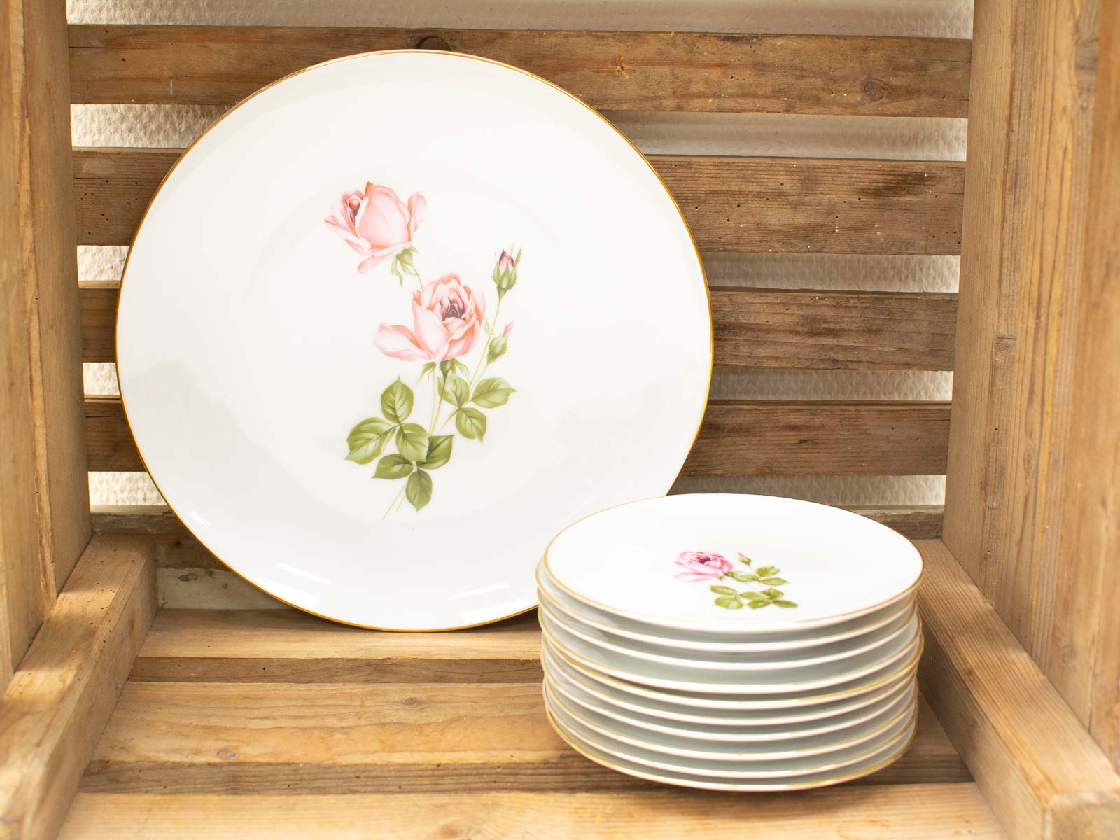 Vintage rose plate set in rustic wooden crate, blending elegance with farmhouse charm.