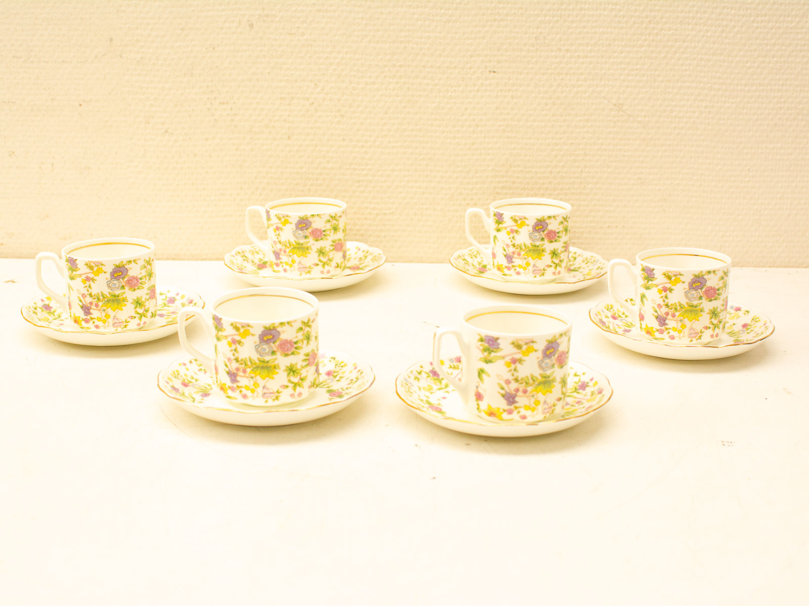 Elegant floral porcelain coffee cups and saucers with gold trim for lovely gatherings.