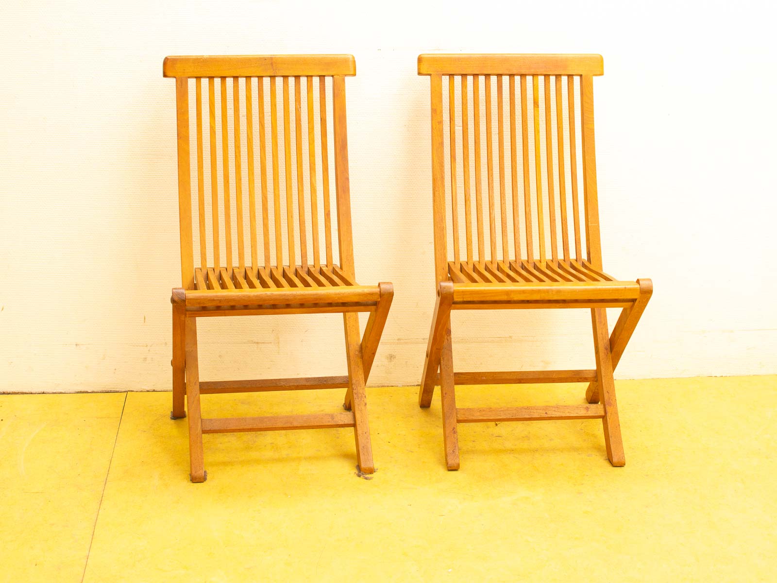 Elegant wooden chairs on a cheerful yellow floor, inviting comfort and style in any space.