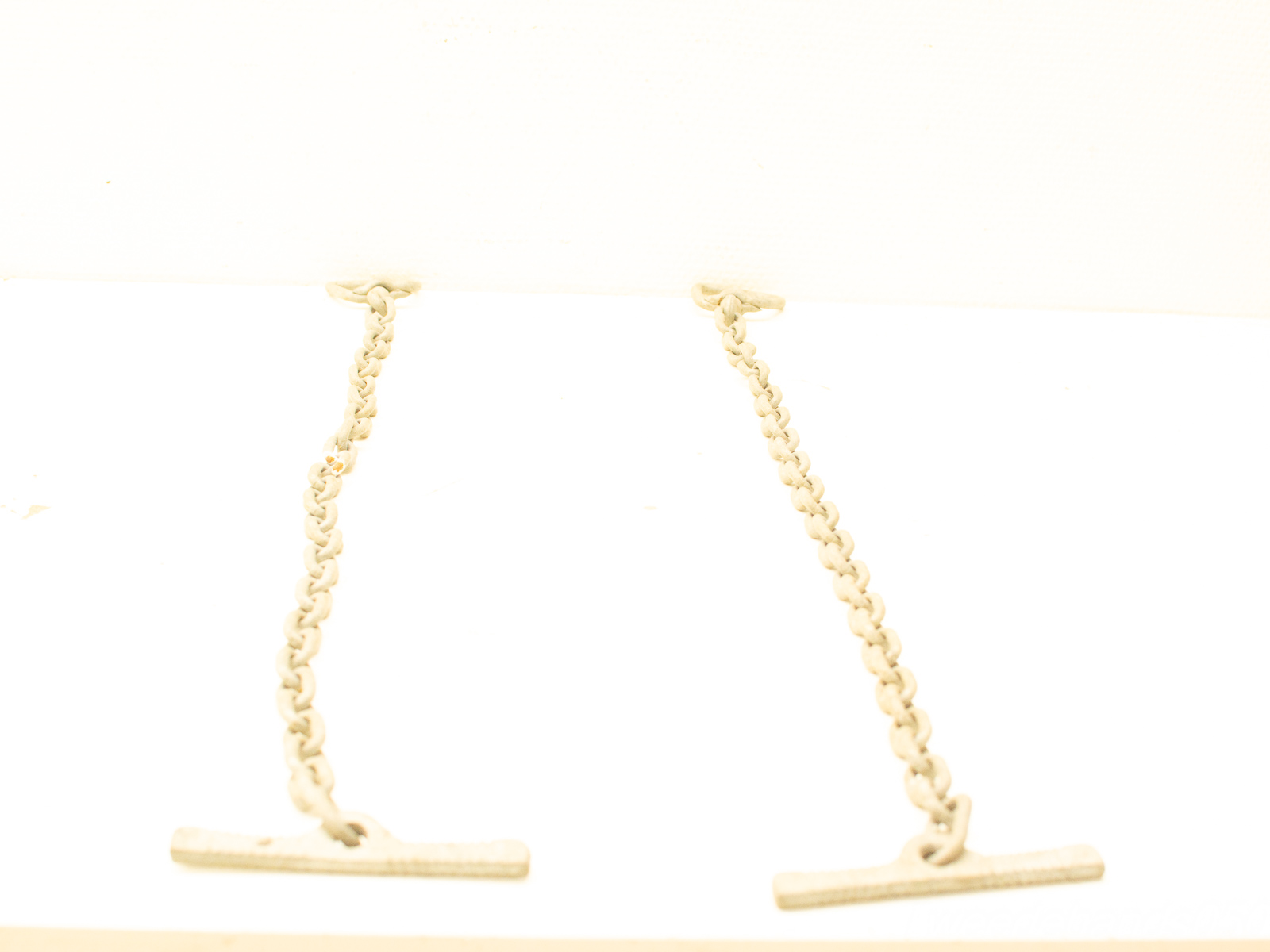 Elegant chains suspended on a minimalist white background for decorative or functional use.