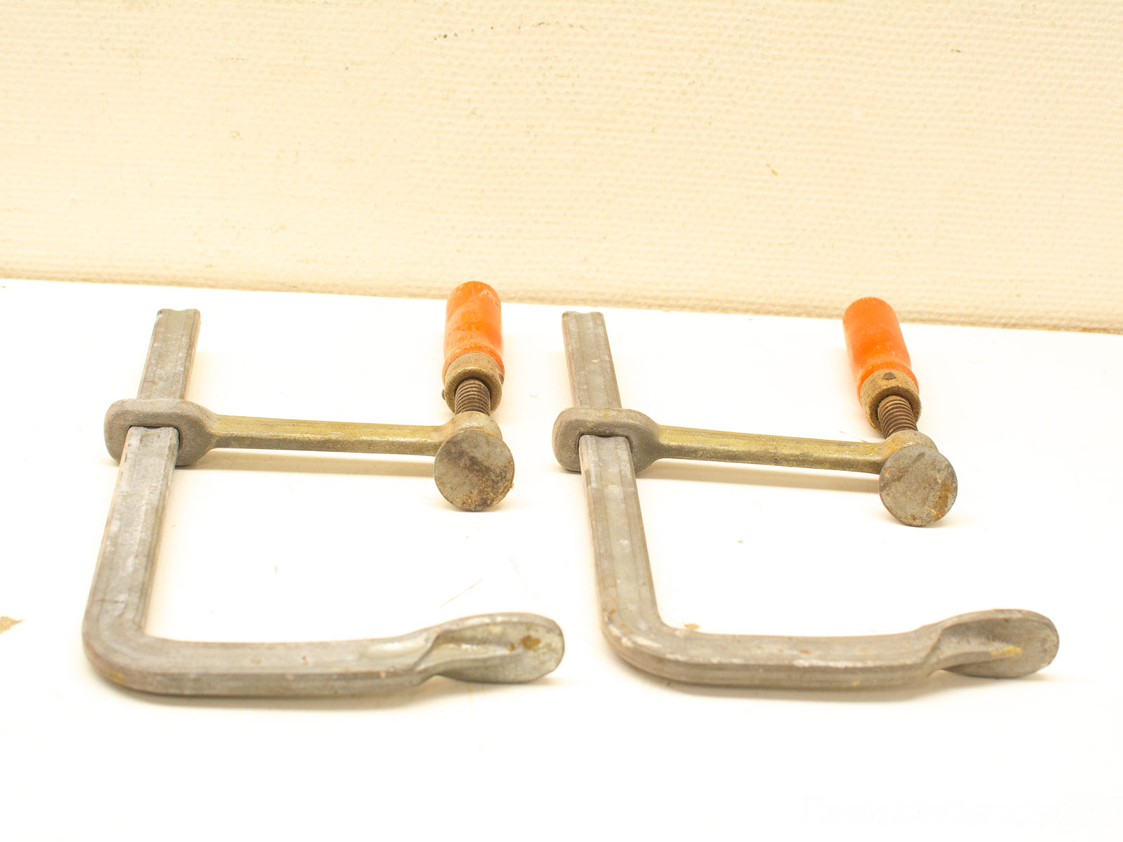 Durable used clamps for woodworking and metalworking with orange handles for easy grip.