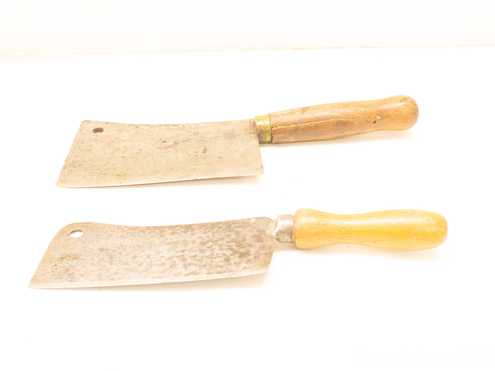 Vintage kitchen cleavers with wooden handles, perfect for cooking enthusiasts and quality tool collectors.