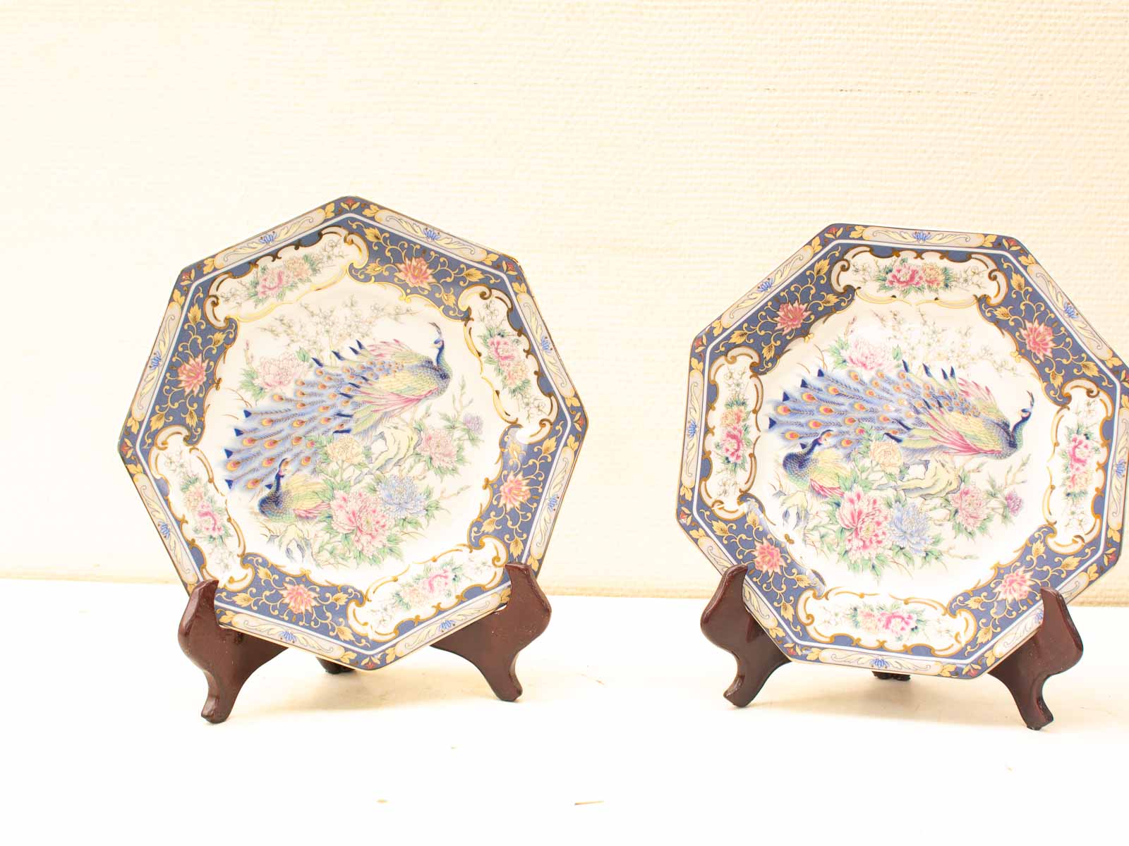 Elegant octagonal decorative plates with vibrant peacock designs and luxurious gold accents.