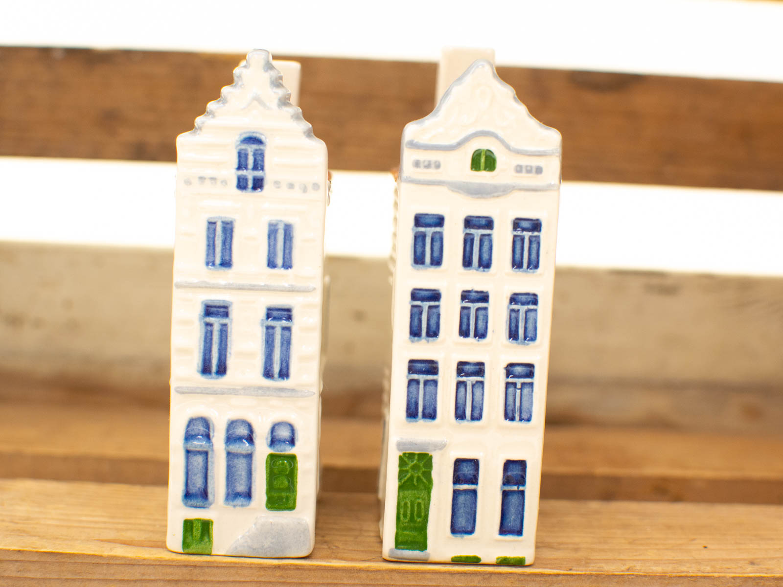 Charming ceramic houses in European style on rustic wood, evoking cozy village nostalgia.