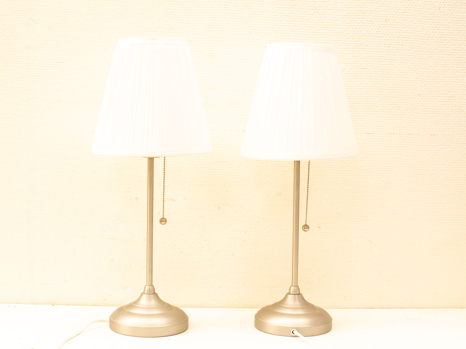 Elegant modern white pleated table lamps with sleek metallic bases for stylish home decor.