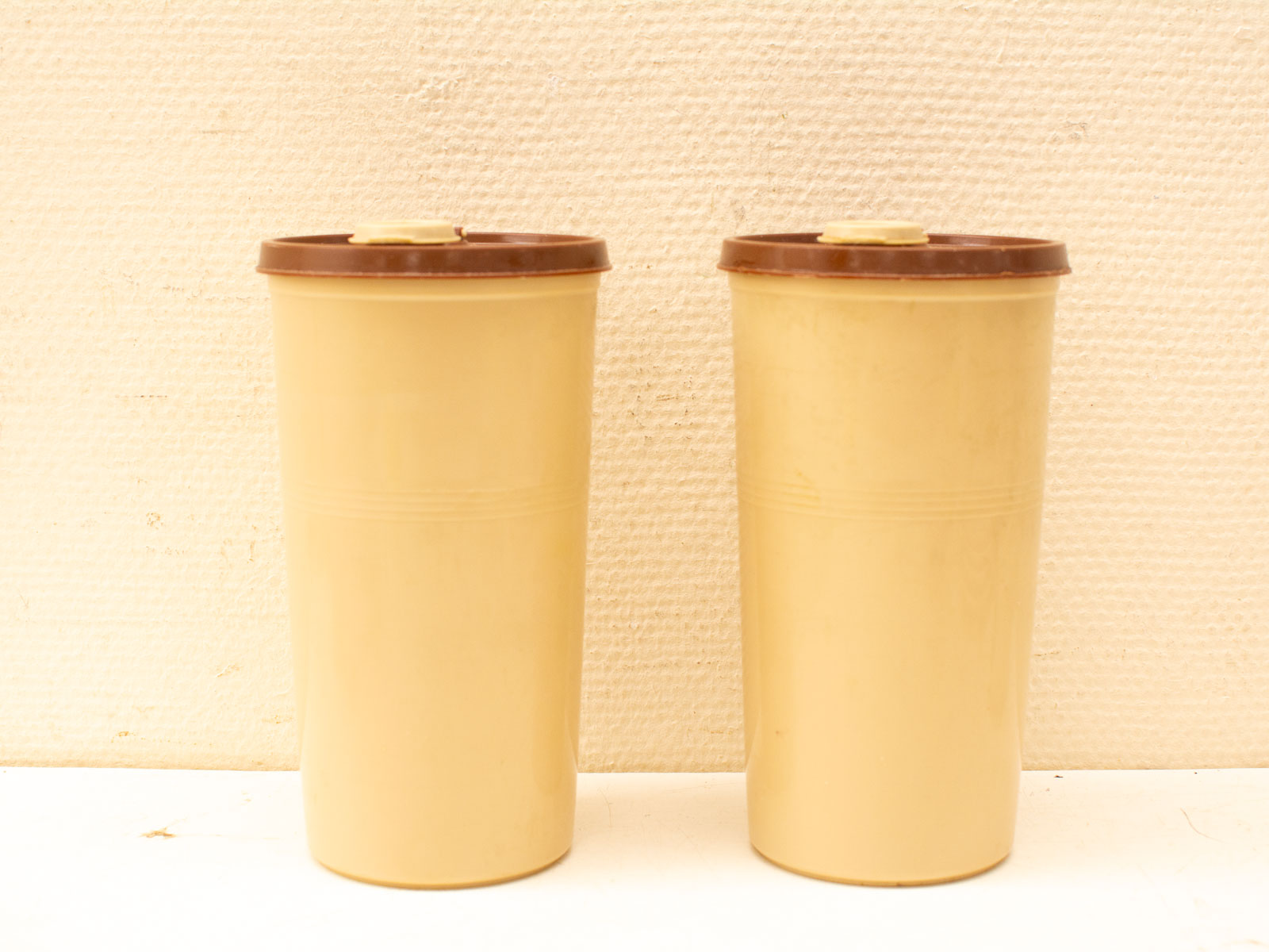 Charming retro yellow containers with brown lids, perfect for stylish storage and decor.