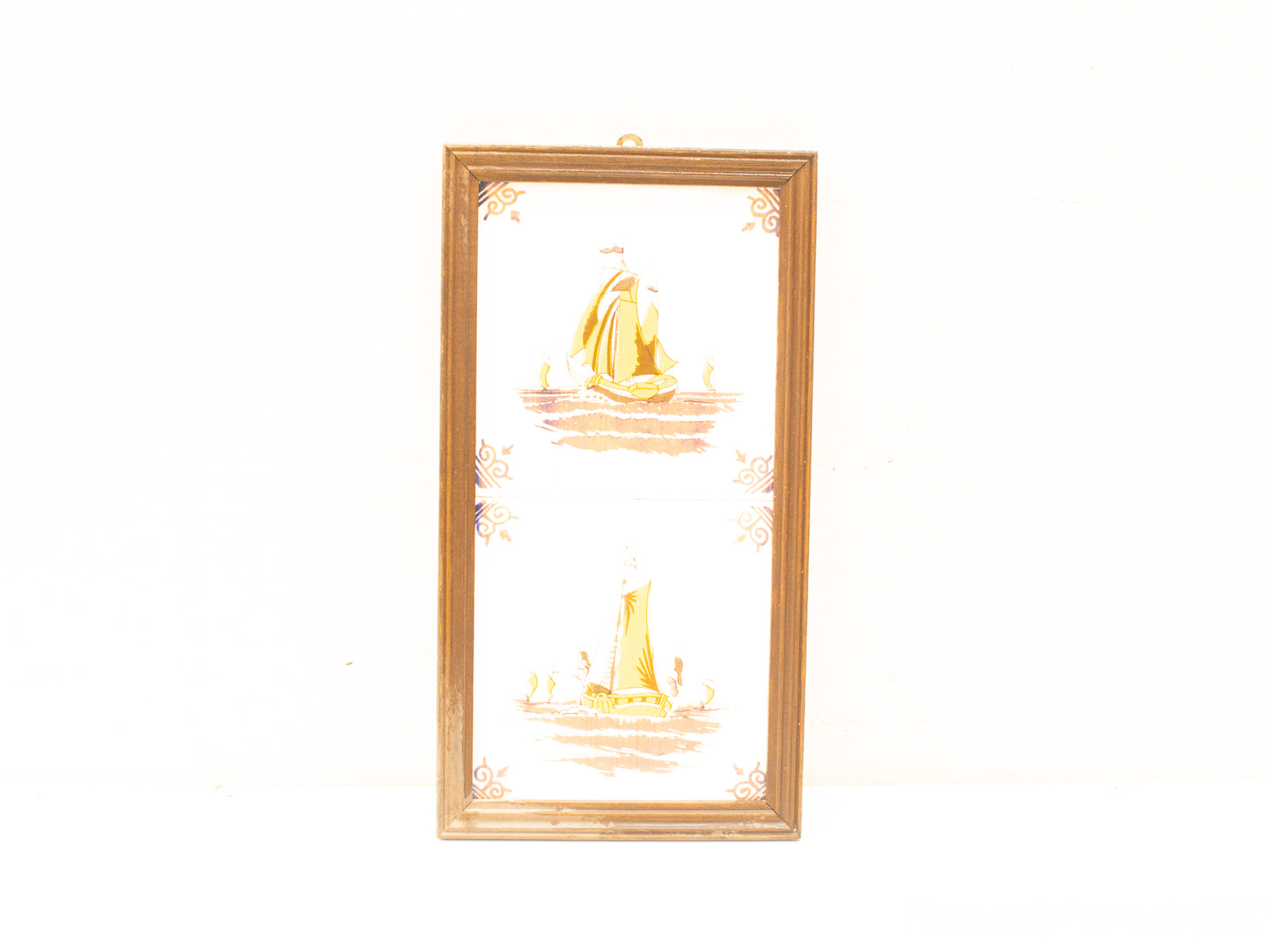 Elegant vintage sailboats artwork in a warm wooden frame, perfect for nautical decor.