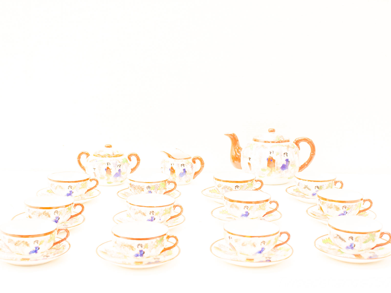 Elegant vintage tea set with floral motifs in soft whites and creams for special occasions.