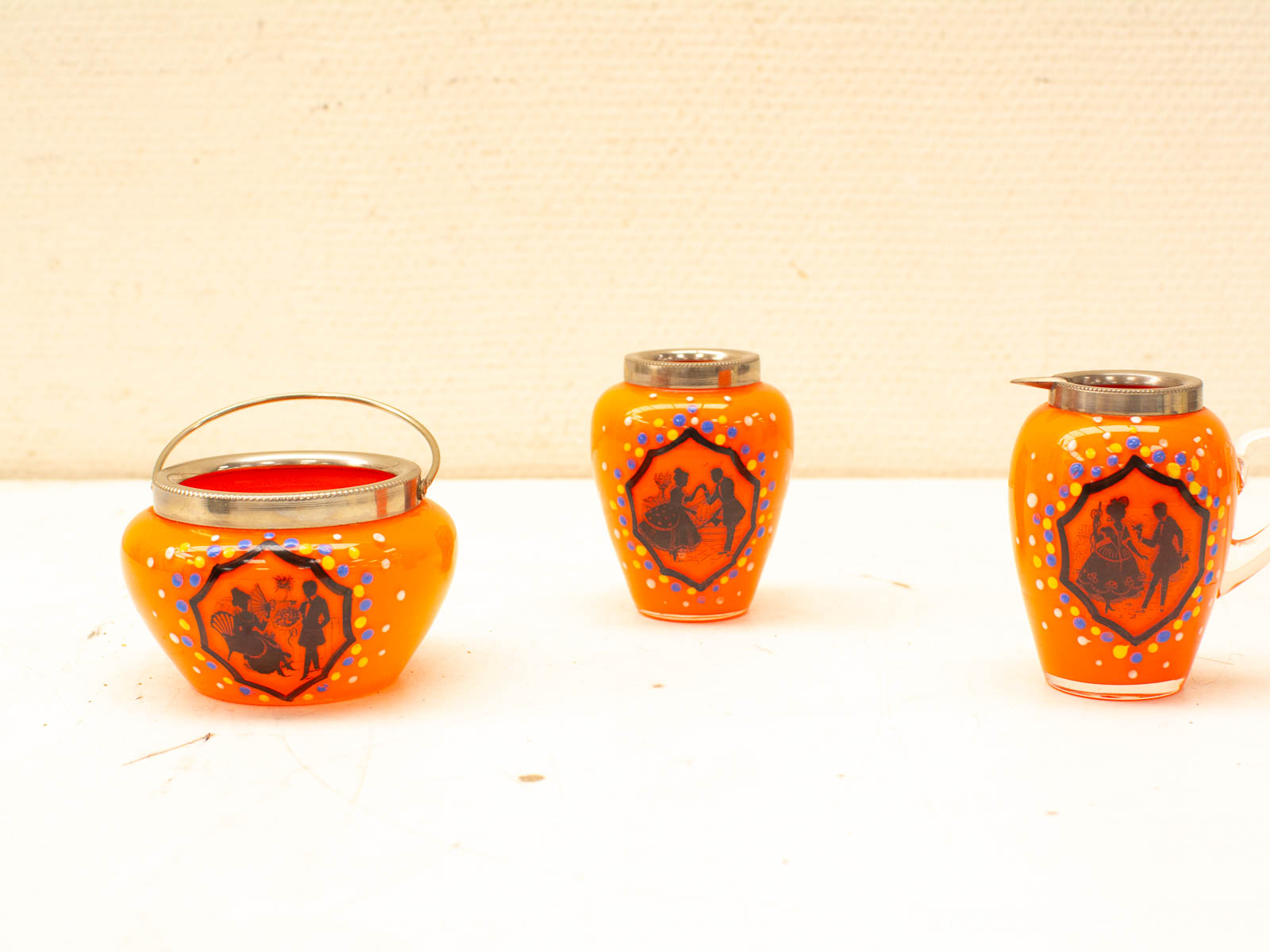 Vibrant orange glass containers with black silhouettes, perfect for stylish home decor and functionality.