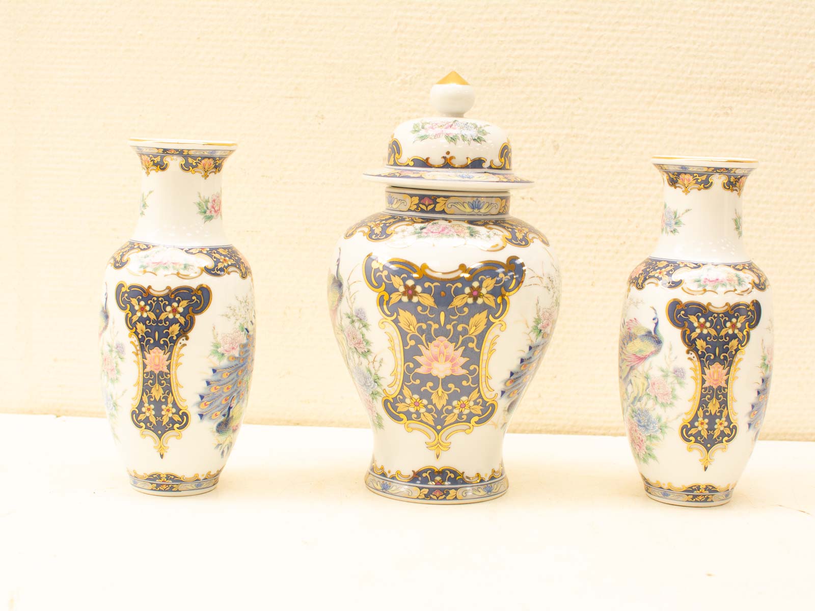 Exquisite trio of porcelain vases with floral designs and gold accents for elegant decor.